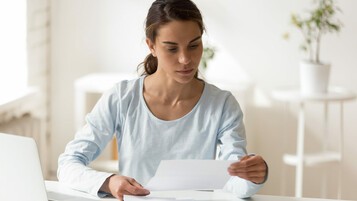 femme en t-shirt blanc lit un courrier