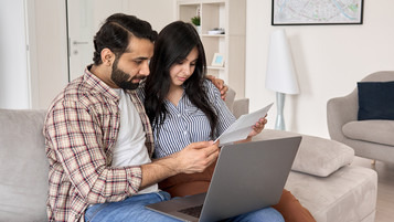 couple devant un ordinateur lit du courrier