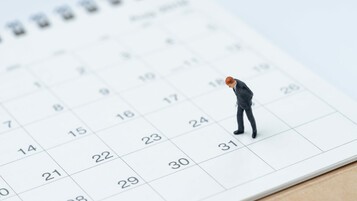 Bonhomme penché sur un calendrier