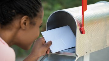 Personne qui récupère son chèque énergie dans sa boîte aux lettres