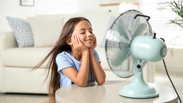Enfant devant un ventilateur