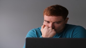 Homme inquiet consultant son ordinateur