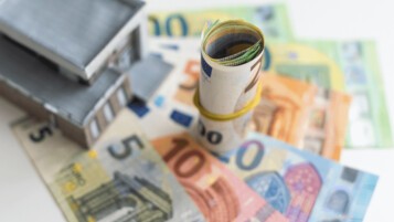 Maquette de maison et billets en euros illustrant le ROI d'une rénovation énergétique