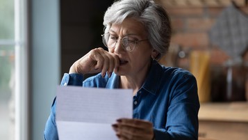 femme âgée lisant un courrier avec un air concentre