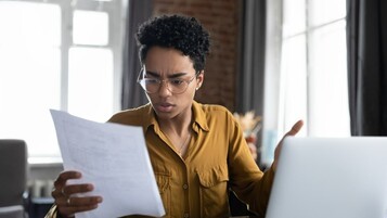 une femme reçoit une facture, air inquiet