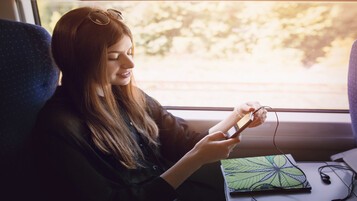 Jeune femme sur son téléphone à bord d'un train
