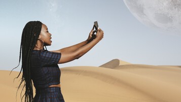 Femme dans le désert utilisant son smartphone