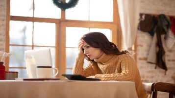 Femme consultant son ordinateur chez elle