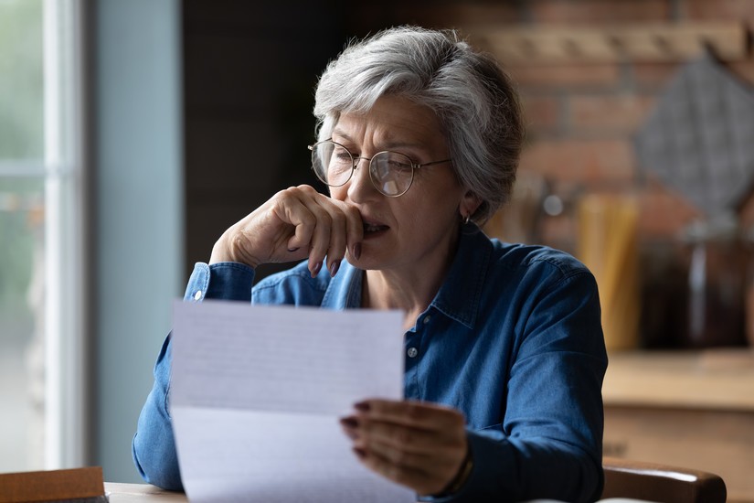 femme âgée lisant un courrier avec un air concentre