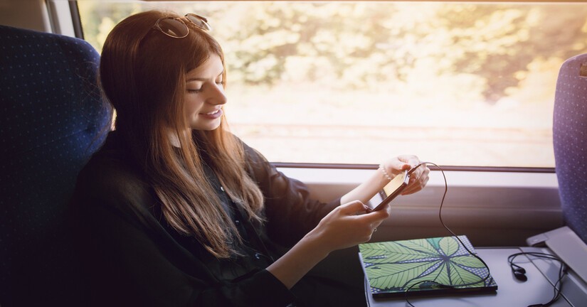 Jeune femme sur son téléphone à bord d'un train